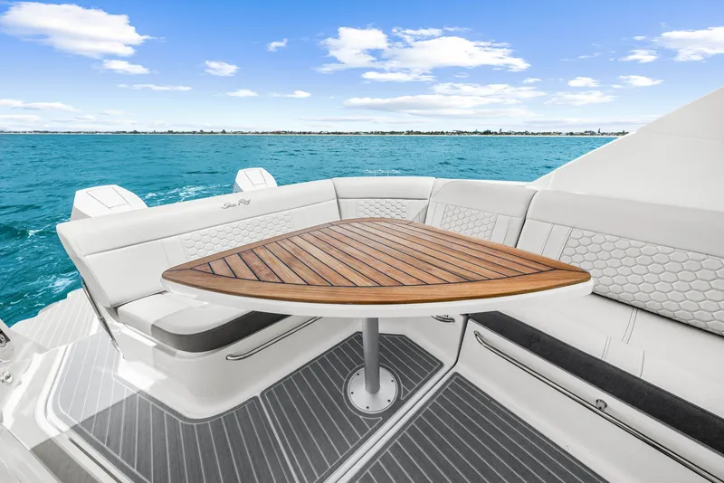 Slide: The Image of The image shows the stern of a Sea Ray Sundancer 320 Outboard with a sleek wooden table. - 31