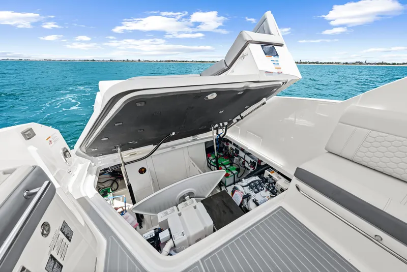 Slide: The Image of The image shows the engine compartment of a 2027 Sea Ray Sundancer 320 Outboard, set on calm waters. - 46
