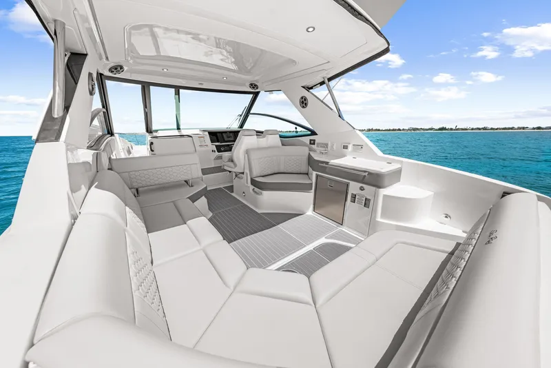 Slide: The Image of The image shows the spacious cockpit of a Sea Ray Sundancer 320 Outboard with luxurious white seating. - 27