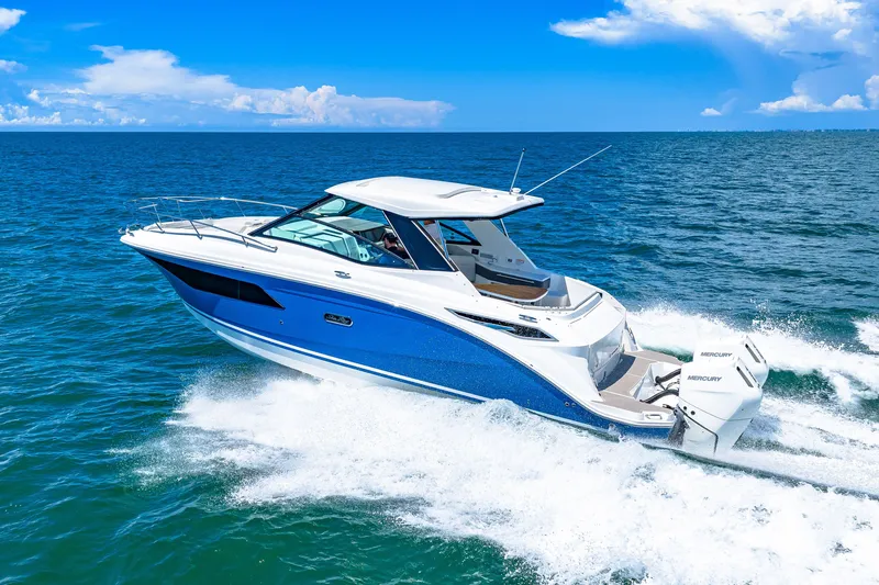 Slide: The Image of A 2027 Sea Ray Sundancer 320 Outboard speeds across the blue sea under a clear sky. - 9