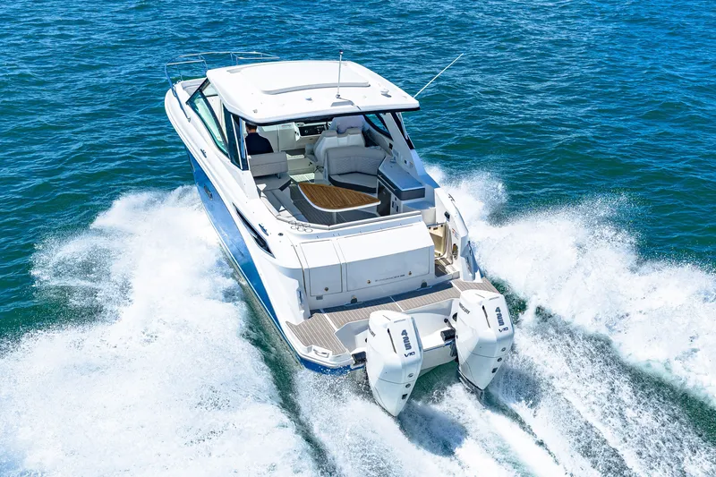 Slide: The Image of A 2027 Sea Ray Sundancer 320 Outboard speeds across the water, featuring twin outboard engines. - 11