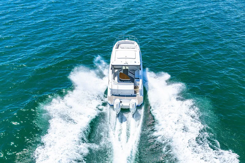 Slide: The Image of A 2027 Sea Ray Sundancer 320 Outboard speeds across the blue water. - 8