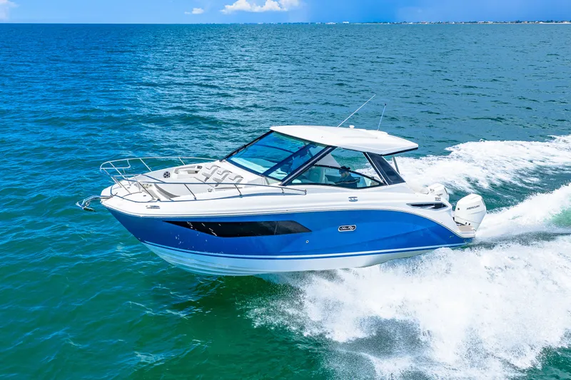 Slide: The Image of 2027 Sea Ray Sundancer 320 Outboard on the water, featuring a blue hull and white deck. - 2