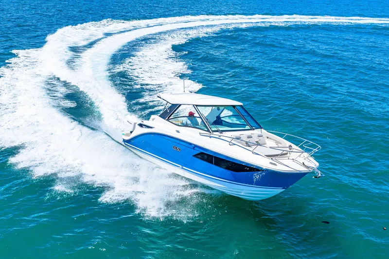 Slide: The Image of A 2027 Sea Ray Sundancer 320 Outboard speeds across the blue sea, leaving a white wake. - 12