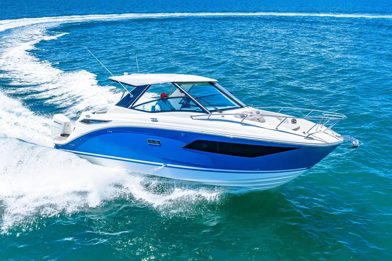 Slide: The Image of A blue and white 2027 Sea Ray Sundancer 320 Outboard speeds across the ocean. - 6
