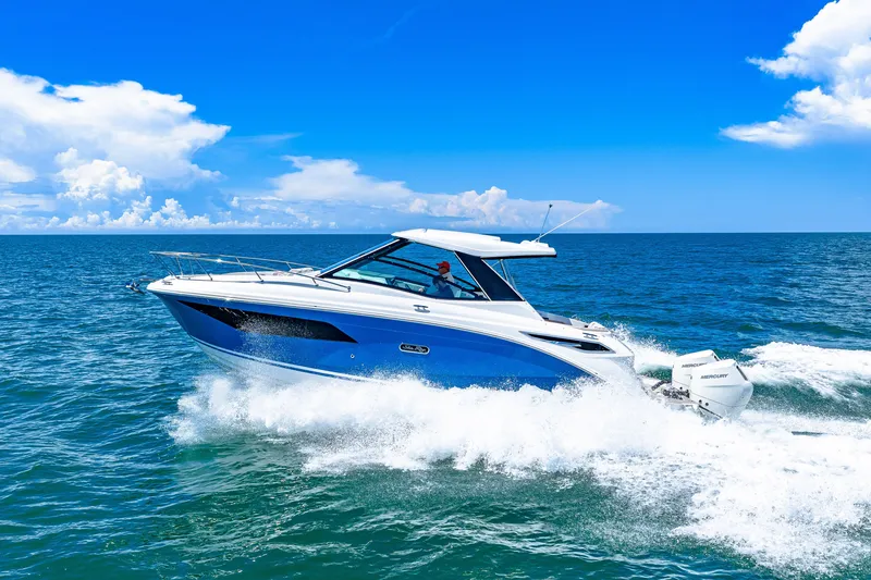 Slide: The Image of A 2027 Sea Ray Sundancer 320 Outboard speeds across the blue sea under a clear sky. - 0