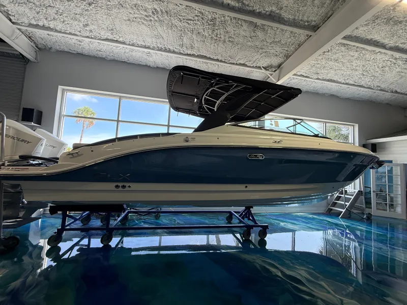 Slide: The Image of A 2027 Sea Ray SLX 280 Outboard is displayed in a modern showroom with large windows. - 1