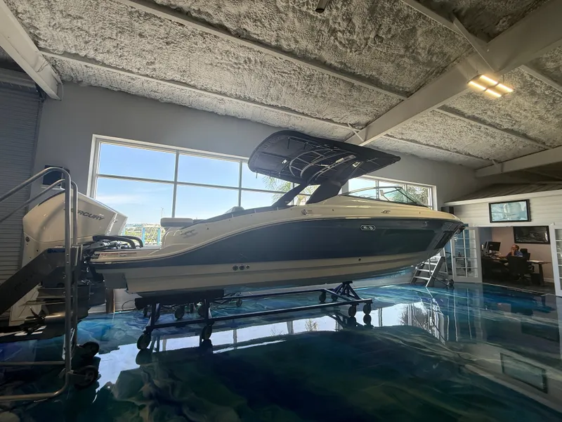 Slide: The Image of A 2027 Sea Ray SLX 280 Outboard is displayed on a trailer in a modern showroom. - 2
