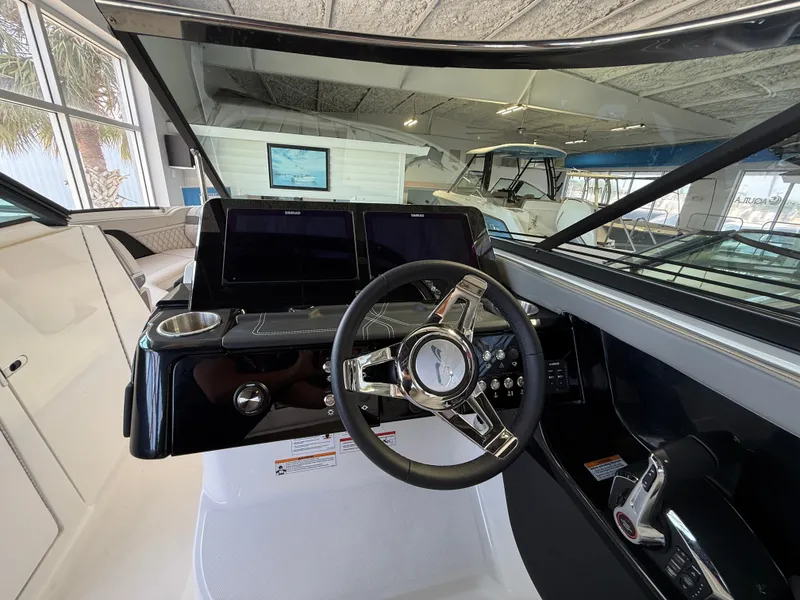 Slide: The Image of The cockpit of the Sea Ray SLX 280 Outboard features a modern dashboard with dual screens and a sleek steering wheel. - 11