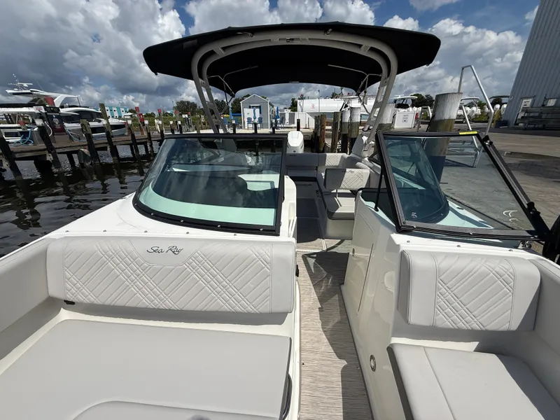 Slide: The Image of The image shows a Sea Ray SDX 270 Outboard boat with sleek white seating and a black sunshade. - 5