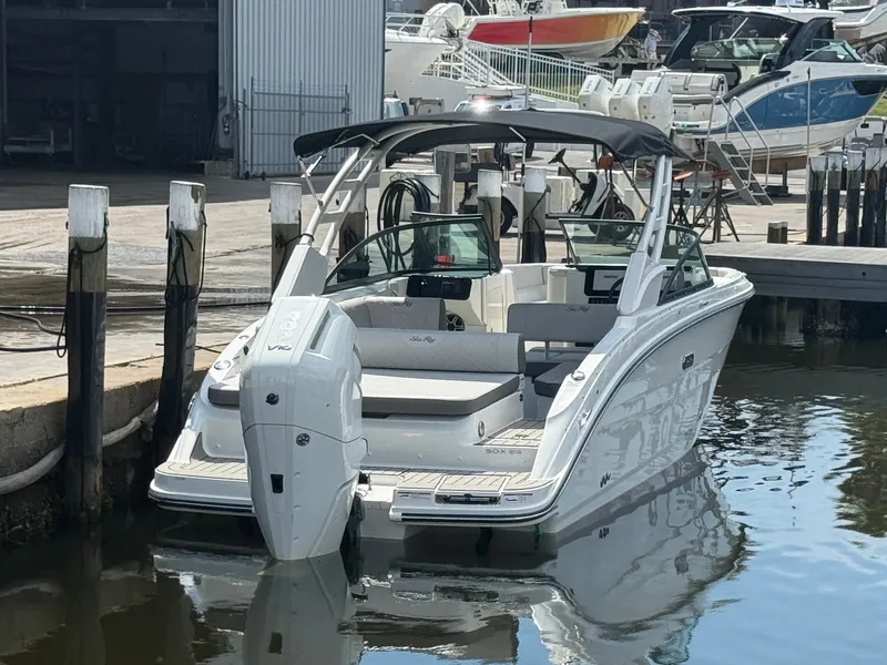 Slide: The Image of The image shows a 2027 Sea Ray SDX 270 Outboard boat docked at a marina. - 2