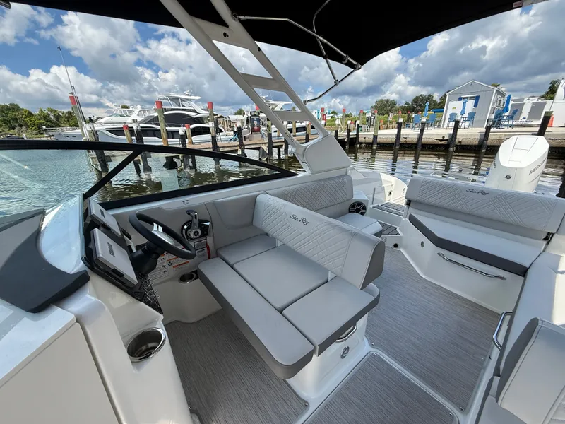 Slide: The Image of The image shows the cockpit of a 2027 Sea Ray SDX 270 Outboard with gray upholstery. - 7
