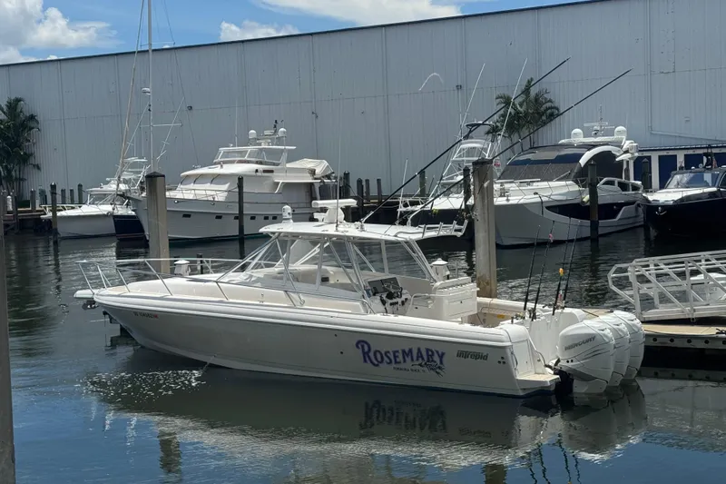 The Image of 2006 Intrepid 377 Walkaround boat docked in marina with other yachts. - 0