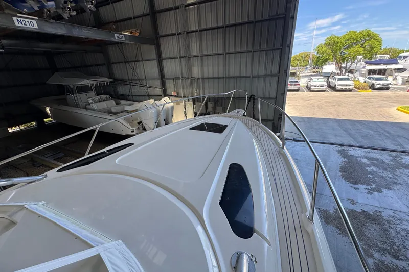 Slide: The Image of 2006 Intrepid 377 Walkaround boat in storage, partially outdoors, with visible deck and railing. - 18
