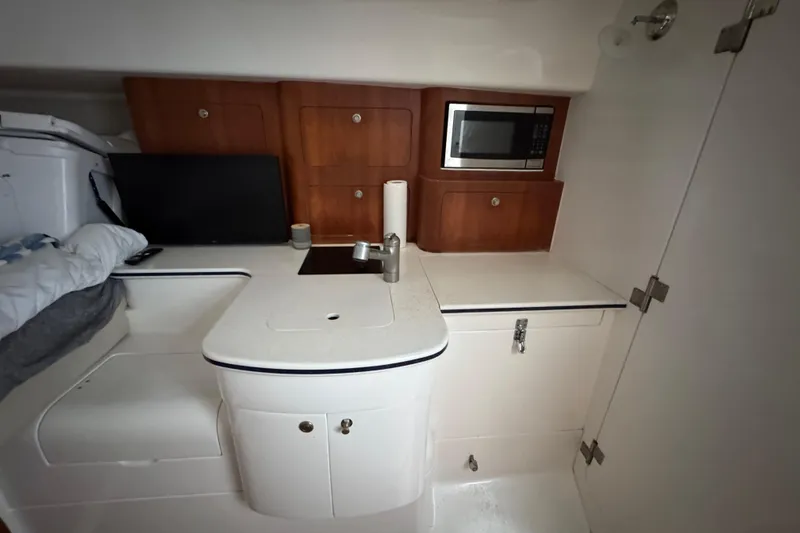 Slide: The Image of Compact kitchen area in a 2006 Intrepid 377 Walkaround boat with microwave and storage. - 22