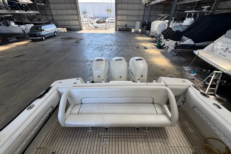 Slide: The Image of 2006 Intrepid 377 Walkaround boat in storage, featuring triple outboard engines. - 25