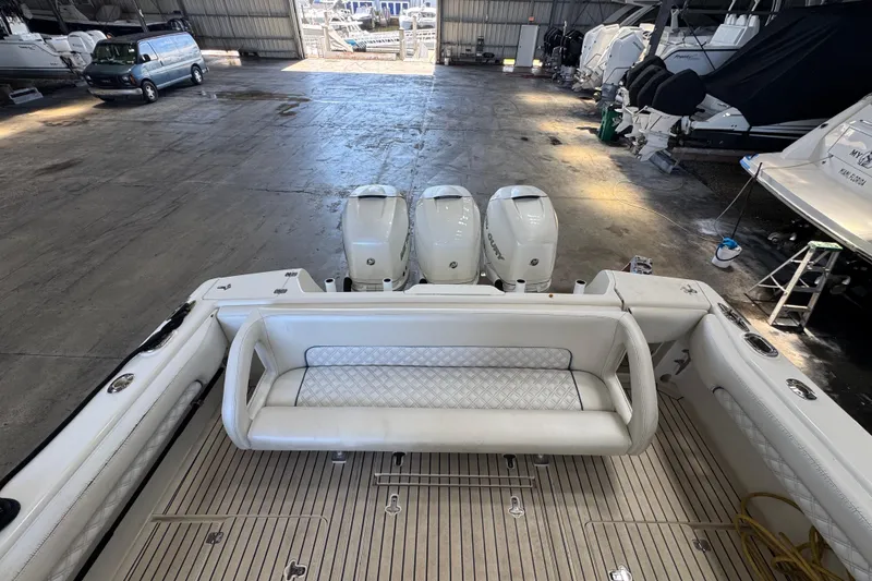 Slide: The Image of 2006 Intrepid 377 Walkaround boat with triple outboard engines in a spacious indoor storage facility. - 26