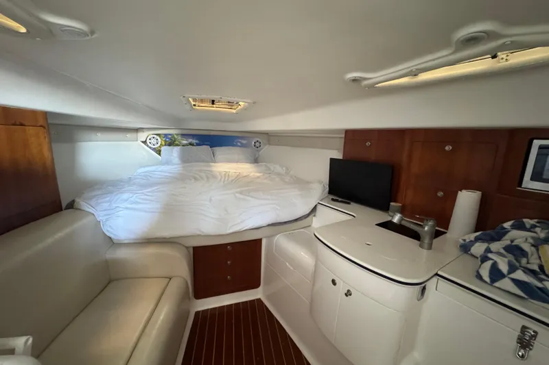 Slide: The Image of Interior of a 2006 Intrepid 377 Walkaround boat with bed, seating, and kitchenette. - 27
