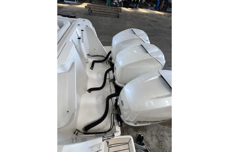 Slide: The Image of 2006 Intrepid 377 Walkaround with triple outboard engines in a warehouse setting. - 29