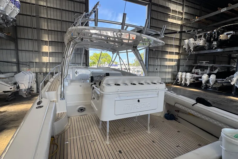 Slide: The Image of 2006 Intrepid 377 Walkaround boat in a storage facility, showcasing sleek design and spacious deck. - 30