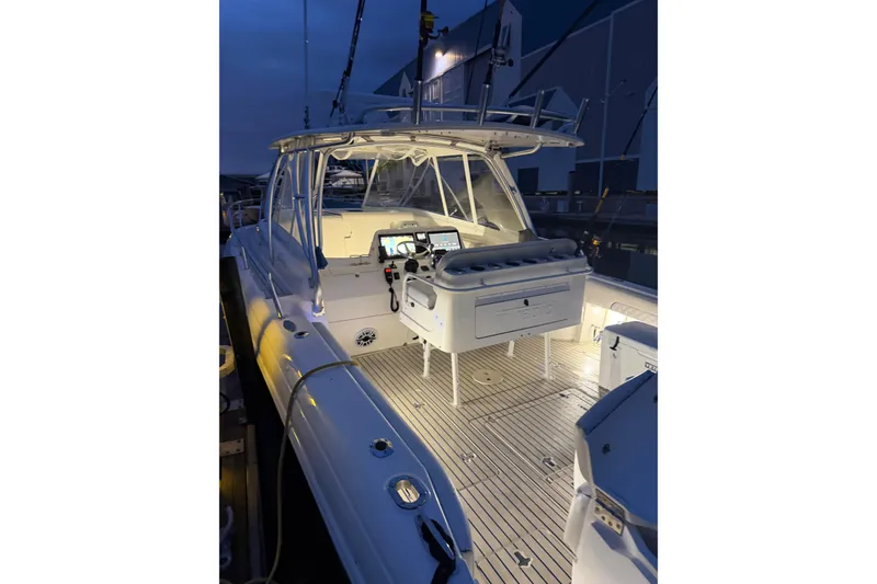 Slide: The Image of 2006 Intrepid 377 Walkaround boat illuminated at night, showcasing cockpit and controls. - 4