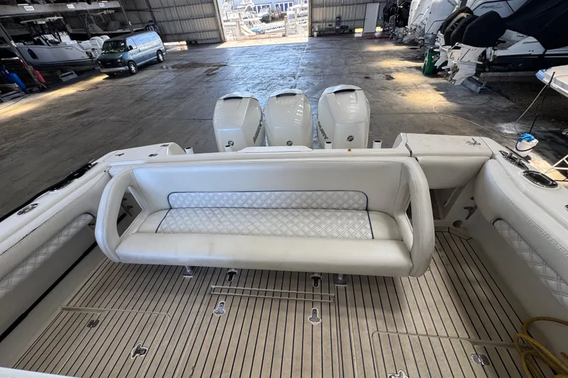 Slide: The Image of 2006 Intrepid 377 Walkaround boat interior with seating and triple outboard engines in a marina. - 8