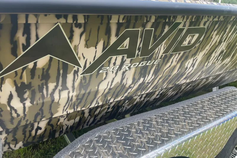 Slide: The Image of Camouflage-patterned Avid 20 Rogue CC boat, 2026 model, on a metallic trailer. - 12