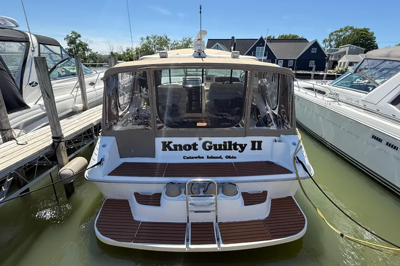 Slide: The Image of 1996 Sea Ray 400 Express Cruiser docked, named "Knot Guilty II," at Catawba Island, Ohio. - 1