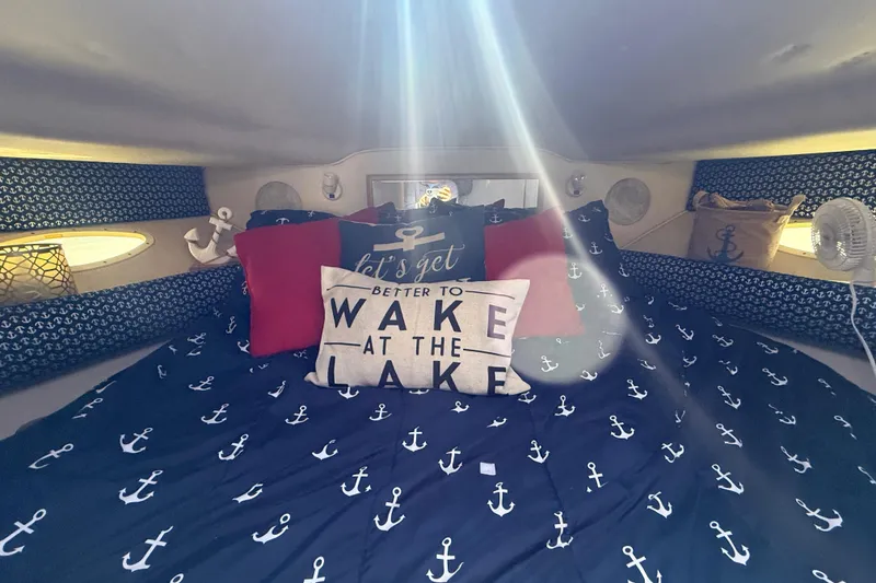Slide: The Image of Cozy cabin interior of 1996 Sea Ray 400 Express Cruiser with nautical-themed bedding. - 47