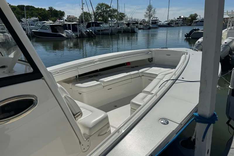 Slide: The Image of 2021 Regulator 31 boat docked in a marina, featuring spacious seating and sleek design. - 6