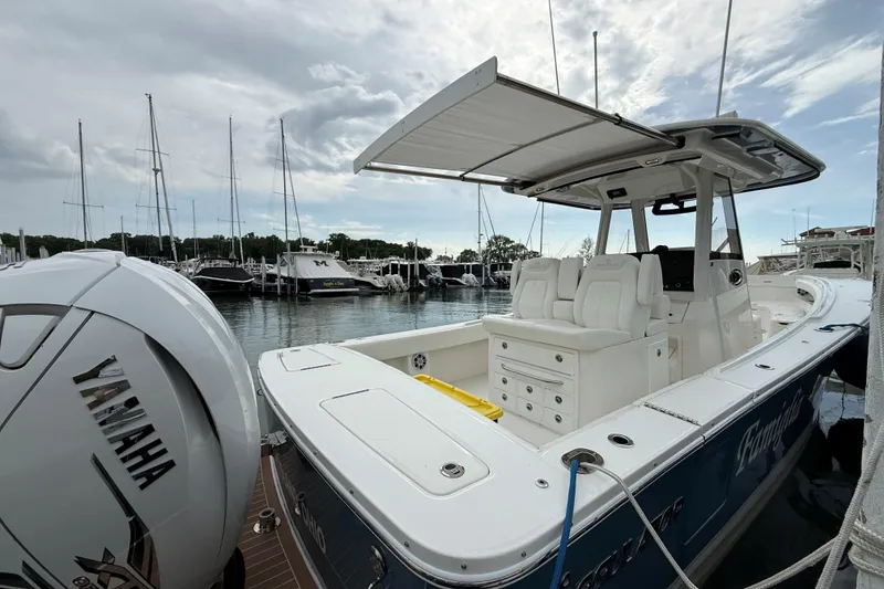 Slide: The Image of 2021 Regulator 31 boat docked, featuring Yamaha engine, with marina and sailboats in background. - 2
