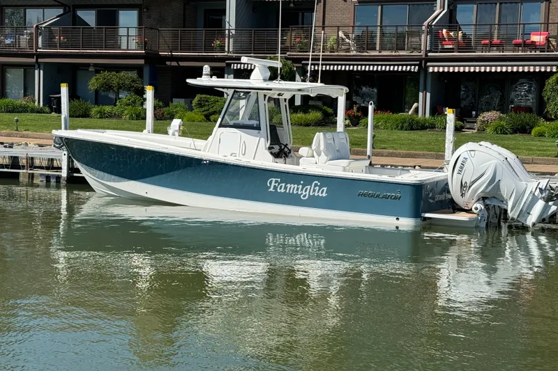 The Image of 2021 Regulator 31 boat docked by waterfront homes. - 0