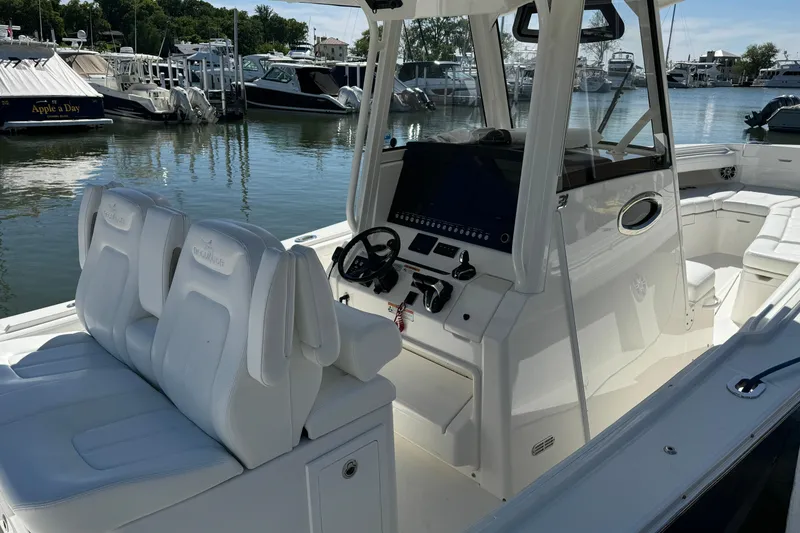 Slide: The Image of 2021 Regulator 31 boat interior with white seating and control panel at marina. - 5