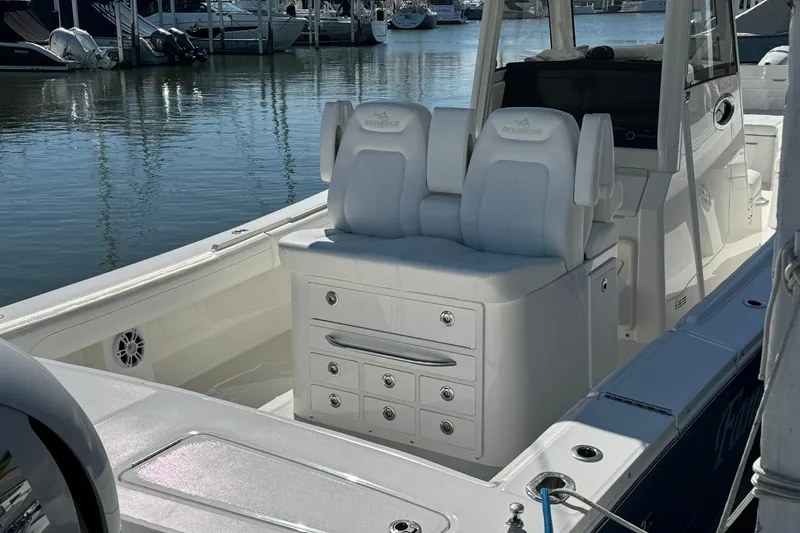 Slide: The Image of 2021 Regulator 31 boat interior with white seating and storage, docked at marina. - 4