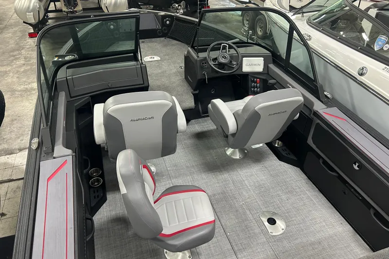 Slide: The Image of 2025 Alumacraft Trophy 185X Sport boat interior with seating and Garmin navigation system. - 11