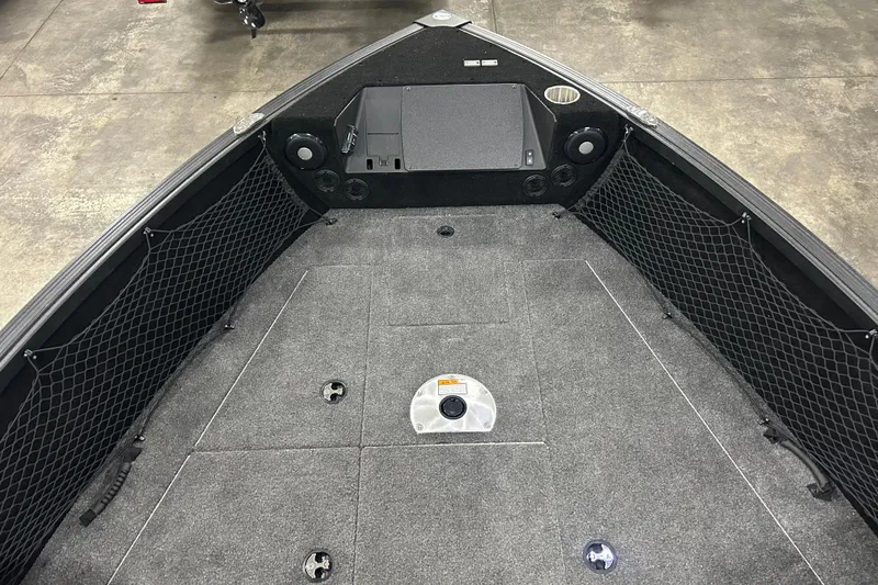Slide: The Image of 2025 Alumacraft Trophy 185X Sport boat interior with carpeted deck and storage nets. - 13