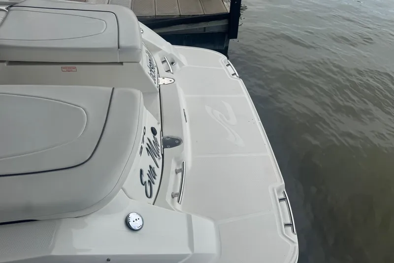 Slide: The Image of 2006 Sea Ray 270 SLX boat docked by the water, showcasing rear seating and swim platform. - 11
