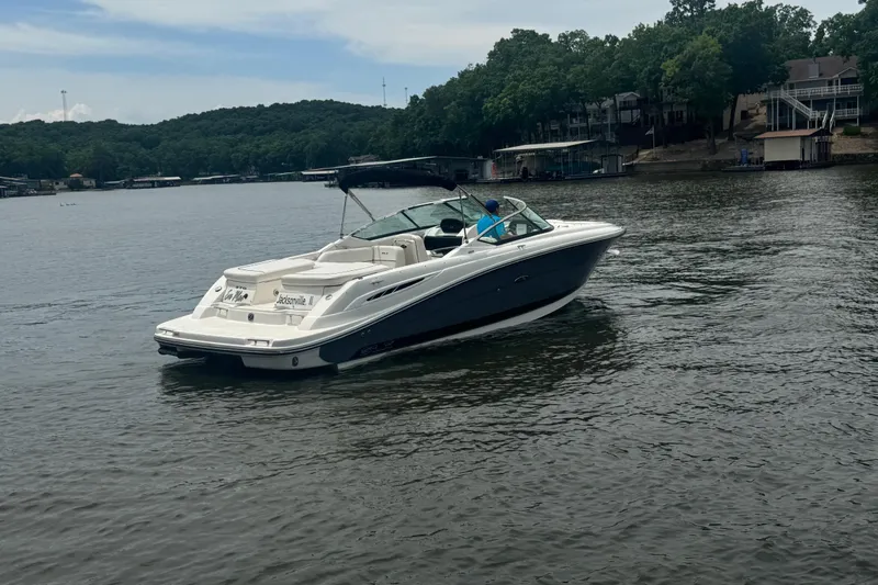 Slide: The Image of 2006 Sea Ray 270 SLX boat cruising on a scenic lake with wooded shoreline. - 3