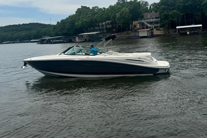 Slide: The Image of 2006 Sea Ray 270 SLX boat cruising on a calm lake with wooded shoreline. - 7