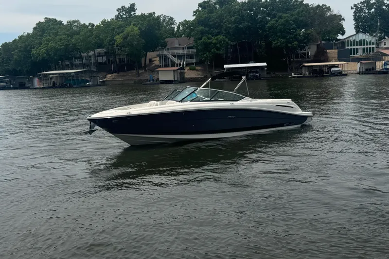 Slide: The Image of 2006 Sea Ray 270 SLX boat on a calm lake with trees and houses in the background. - 8