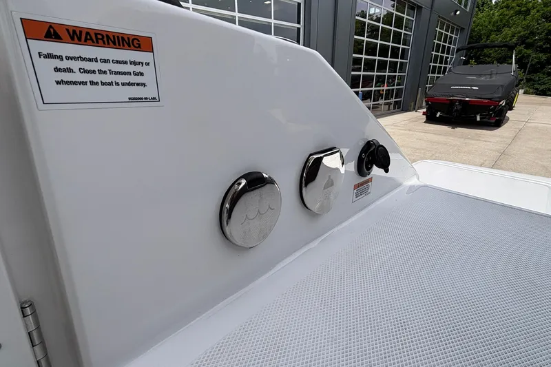 Slide: The Image of 2026 Monterey Elite 27 OB boat with safety warning label and transom gate detail. - 13