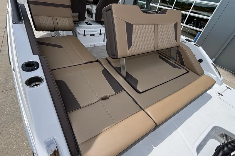 Slide: The Image of 2026 Monterey Elite 27 OB boat interior with tan and brown seating, featuring cup holders. - 15