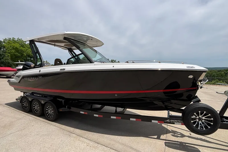 Slide: The Image of 2026 Monterey Elite 27 OB boat on trailer, sleek black design with red accents. - 3