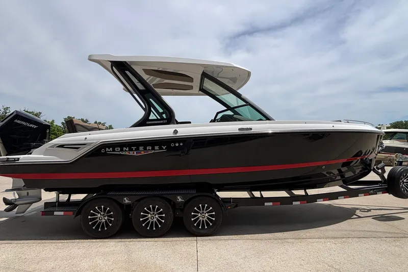 Slide: The Image of 2026 Monterey Elite 27 OB boat on trailer, sleek black design with red accents. - 4