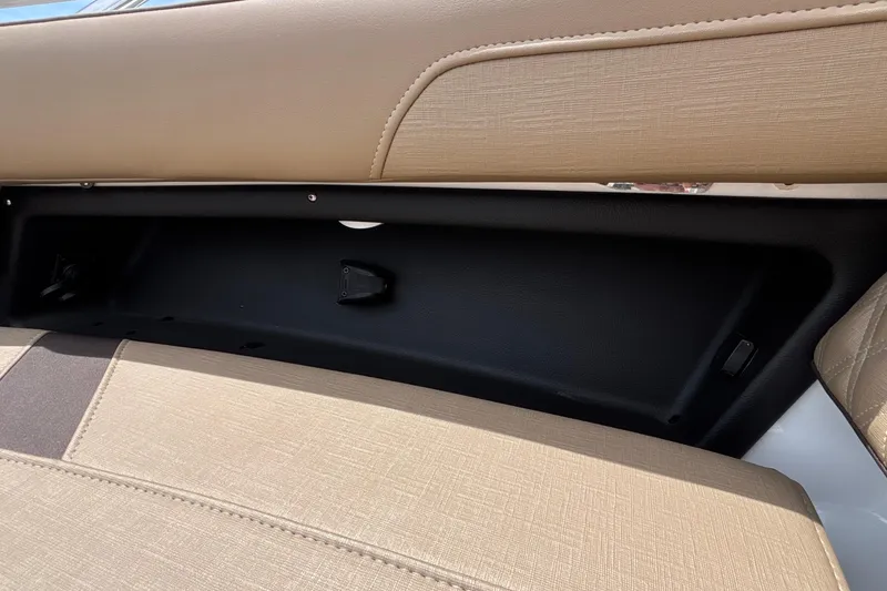 Slide: The Image of Interior seating of 2026 Monterey Elite 27 OB boat, featuring beige upholstery and storage compartment. - 43