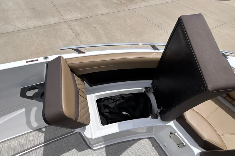 Slide: The Image of 2026 Monterey Elite 27 OB boat with open storage compartment and cushioned seating. - 44