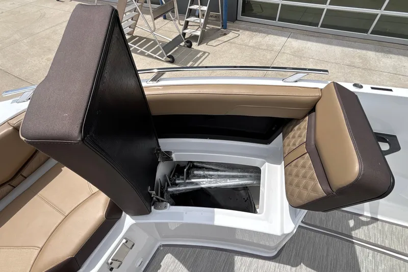 Slide: The Image of 2026 Monterey Elite 27 OB boat with open storage compartment and cushioned seating. - 45