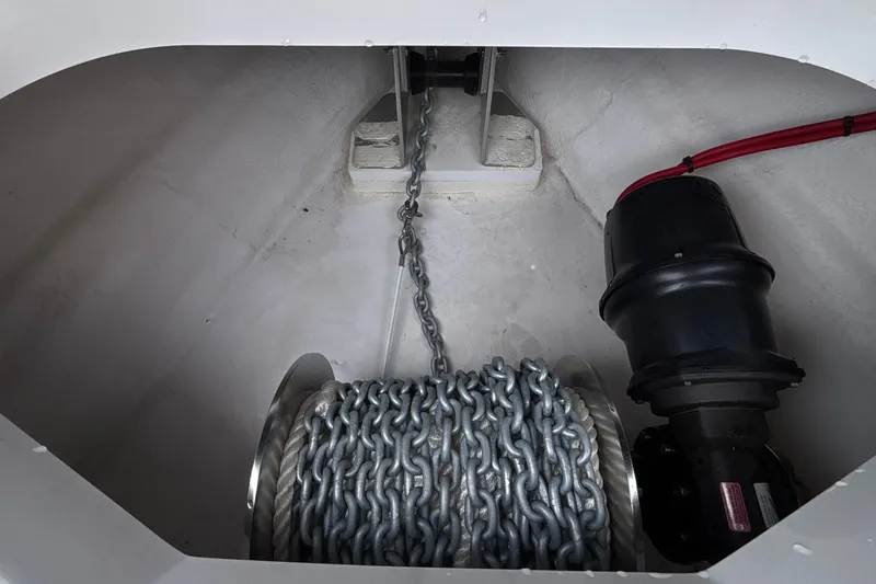 Slide: The Image of Anchor chain compartment of 2026 Monterey Elite 27 OB boat, featuring robust chain and motor. - 47