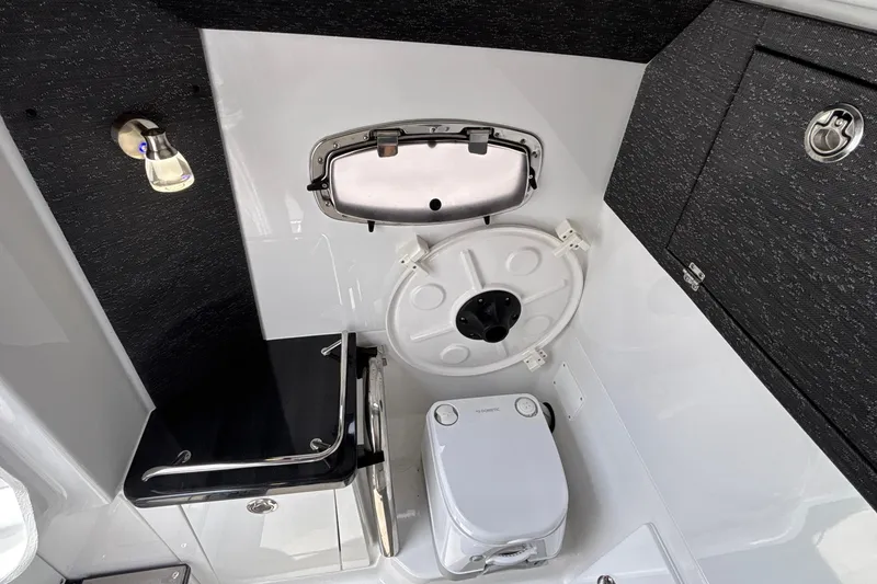 Slide: The Image of Interior of 2026 Monterey Elite 27 OB boat featuring compact bathroom amenities. - 51
