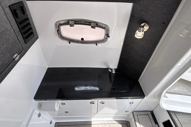 Slide: The Image of Interior of 2026 Monterey Elite 27 OB boat with sleek black countertop. - 52